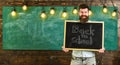 Hiring teachers concept. Teacher in eyeglasses holds blackboard with title back to school. Man with beard and mustache