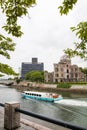 Hiroshima,Japan-July 2019: Hiroshima Peace Memorial Park Atomic Bomb Dome with tourist cruise boat at the river Royalty Free Stock Photo