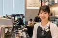 Japanese female barista smiling looking camera at a coffee shop.