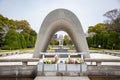 Hiroshima Peace Memorial Cenotaph with flowers and park view Royalty Free Stock Photo