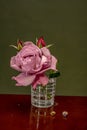 Elegant Serenity: Luxurious Rose in a Water-Filled Glass with Delicate Snail in the Foreground