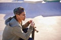 His favourite place to think. A young skater sitting down at a skate park.