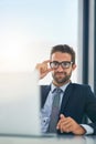 His focus is directed at achieving great success. Portrait of a handsome young businessman working on a laptop in an