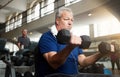 His got that determination to get fit. a senior man working out with weights at the gym. Royalty Free Stock Photo