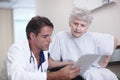 His medical findings at the touch of a button. A male doctor showing his senior patient her medical report on his Royalty Free Stock Photo