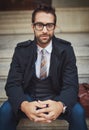 His style speaks of who he is. Portrait of a stylish young man sitting on steps in the city. Royalty Free Stock Photo