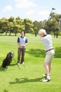 His swing is looking good. Golfing companions out on the course playing a round of golf. Royalty Free Stock Photo