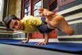 On his terrace, a young Asian girl with a stunning appearance is practicing Yoga while sporting a short haircut, a yellow shirt,