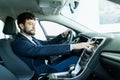 Portrait of a mature man smiling happily sitting in a brand new car touching the dashboard Royalty Free Stock Photo