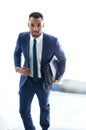 On his way to a meeting. A handsome african american businessman walking up the stairs while carrying a bag. Royalty Free Stock Photo