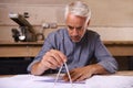 His work is always very accurate. a draftsman using a triangle and compass to draw up building plans.