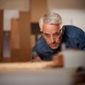 His workmanship is of the highest quality. a mature male carpenter working on a project in his workshop. Royalty Free Stock Photo