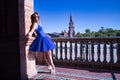 Hispanic adult female classical ballet dancer in blue tutu doing figures on the terrace of a plaza next to a beautiful tiled