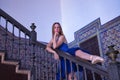 Hispanic adult female classical ballet dancer in blue tutu making figures on a beautiful metal staircase railing Royalty Free Stock Photo