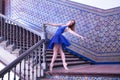 Hispanic adult female classical ballet dancer in blue tutu making figures on a beautiful metal staircase railing Royalty Free Stock Photo