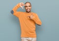 Hispanic adult man wearing casual winter sweater smiling making frame with hands and fingers with happy face Royalty Free Stock Photo