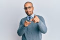 Hispanic adult man wearing glasses and business style pointing fingers to camera with happy and funny face