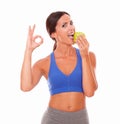 Hispanic adult woman in sportswear biting apple Royalty Free Stock Photo