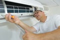 Hispanic airconditioning repair man performing maintenance Royalty Free Stock Photo