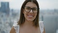 Hispanic beauty in glasses, a carefree, confident woman embracing joy in tokyo\'s urban panorama, posing with a radiant smile and