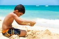 Hispanic boy building a sand castle