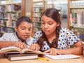 Hispanic Boy and Girl Having Fun Studying Together In The Library Royalty Free Stock Photo