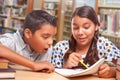 Hispanic Boy and Girl Having Fun Studying Together In The Library Royalty Free Stock Photo