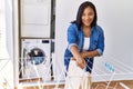 Hispanic brunette woman hanging clean laundry on rack at laundry room Royalty Free Stock Photo