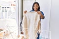 Hispanic brunette woman hanging clean laundry on rack at laundry room Royalty Free Stock Photo