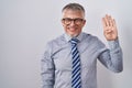 Hispanic business man with grey hair wearing glasses showing and pointing up with fingers number four while smiling confident and Royalty Free Stock Photo