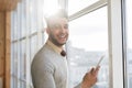 Hispanic Business Man Using Cell Smart Phone Stand in front Panoramic Window Happy Smiling Businessman In Coworking Royalty Free Stock Photo