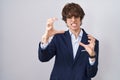 Hispanic business young man wearing glasses shouting frustrated with rage, hands trying to strangle, yelling mad Royalty Free Stock Photo