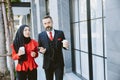 Hispanic Businessman with Asian Arab Muslim business women talking together during coffee break in modern office building Royalty Free Stock Photo