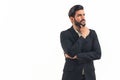 Hispanic businessman with dark slick hair and beard wearing suit looking into the distance with hand on chin thinking