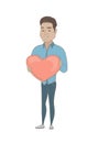 Hispanic businessman holding a big red heart.