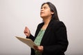 Hispanic Businesswoman Deeply Thinking While Holding Folder