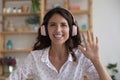 Hispanic businesswoman in headphones looking at camera start video call