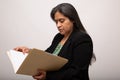 Hispanic Businesswoman Looks Through Folder