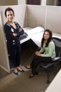 Hispanic businesswomen in cubicle Royalty Free Stock Photo
