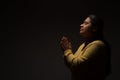 Hispanic Christian Woman Praying or Talking to God on Dark Background