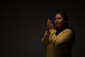 Hispanic Christian Woman Praying or Talking to God on Dark Background