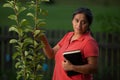 Hispanic Christian Woman Touching Pear Tree and her Bible