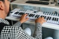 Hispanic composer and musician with a beard playing the keyboard in a scene with the camera very close to him. Royalty Free Stock Photo