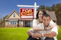 Hispanic Couple New Home and Sold Real Estate Sign Royalty Free Stock Photo