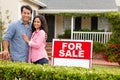 Hispanic couple satnding with a sign outside house Royalty Free Stock Photo