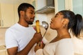 hispanic couple singing together holding a ladle like a microphone in the kitchen Royalty Free Stock Photo