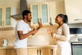 hispanic couple singing together holding a ladle like a microphone in the kitchen Royalty Free Stock Photo