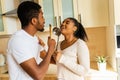 hispanic couple singing together holding a ladle like a microphone in the kitchen Royalty Free Stock Photo