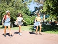 Three young mixed race female friends walking together in the park smiling with sunglasses - Two Caucasian women take a fun walk Royalty Free Stock Photo