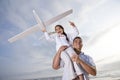 Hispanic dad playing holding girl high on shoulder